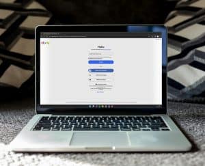 Auf dem Laptop ist das Registrierungsformular für das Händlerportal eBay zu sehen, bei dem man sich auch über andere Dienste wie Google oder Apple registrieren kann.