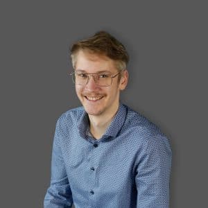 Bild eines blonden junges Mannes mit Brille im blauen Hemd